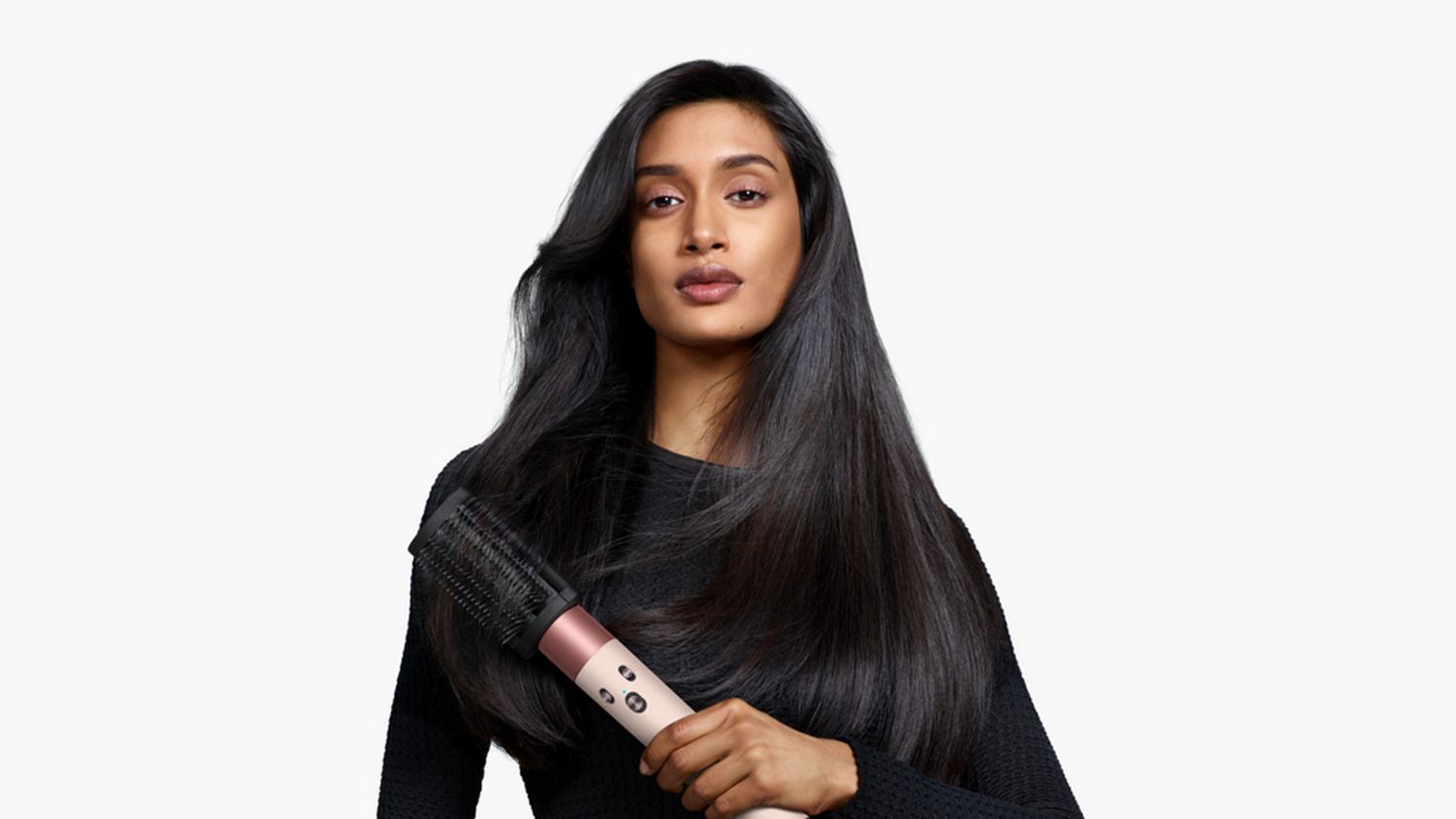 Model holding the Dyson Airwrap ID multi-styler and dryer with the Anti-tangle loop brush.